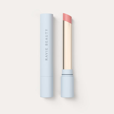 An open tube beside its cap. Ravie Beauty Effortless Lips™ Sheer-Buildable Lip Color in Daisy 