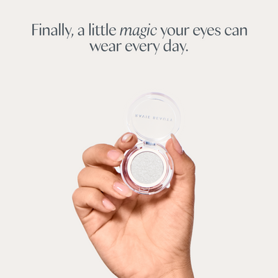 Finally, a little magic your eyes can wear every day. A hand holding the open compact. Ravie Beauty Softlight™ Glistening Eye Topper in Soft Pearl 