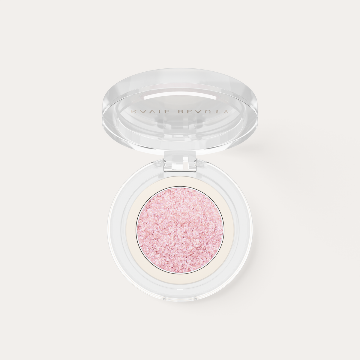 An open compact. Ravie Beauty Softlight™ Glistening Eye Topper in Soft Pink 